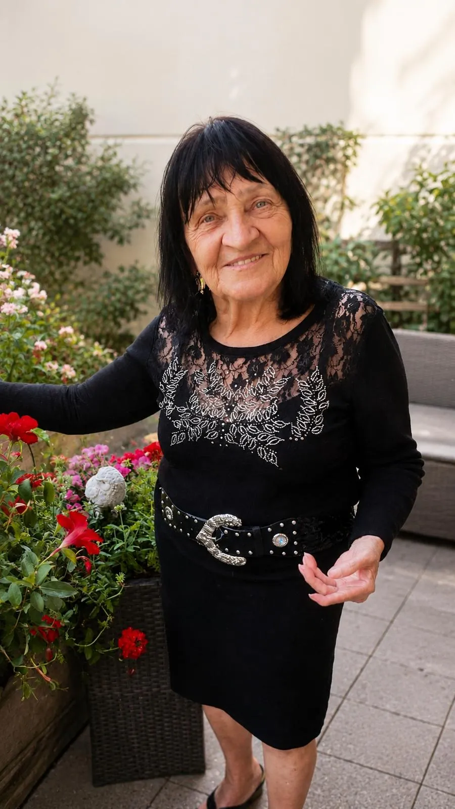 Oma Anna sitzt lächelnd im Garten